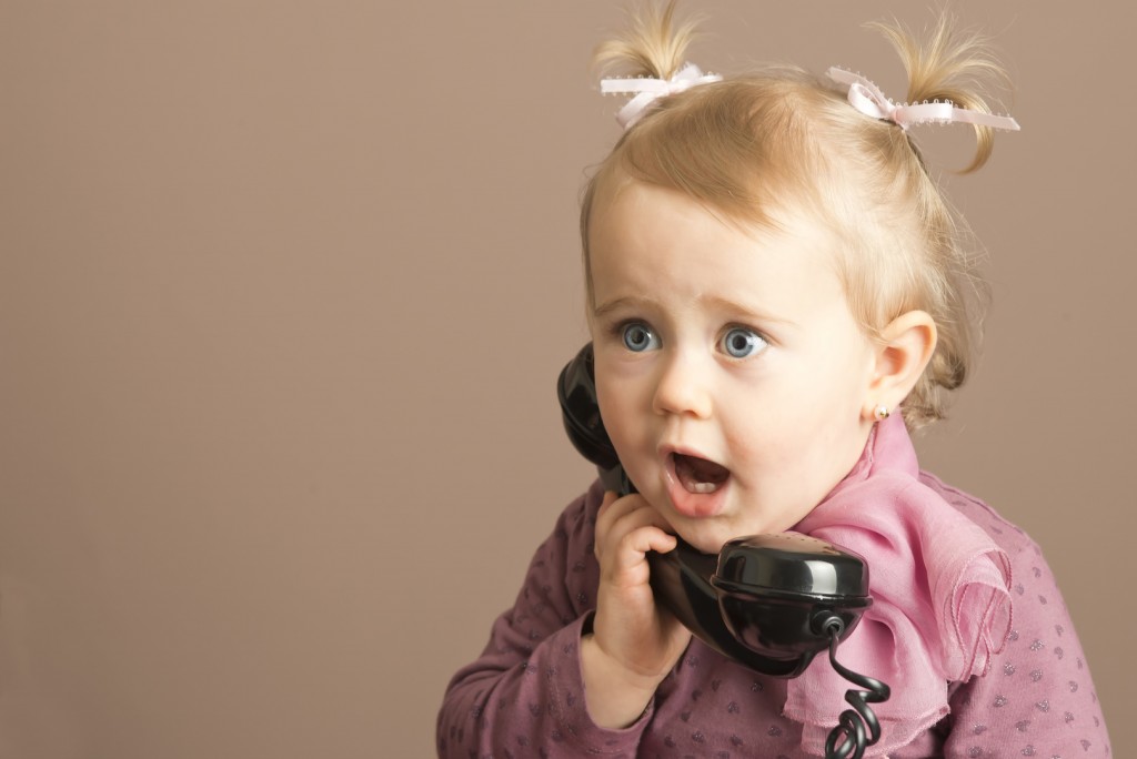 Baby girl in surprise talking on a vintage phone